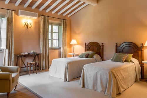 a bedroom with two beds and a chair at Villa Valle, Villa Saletta Wine Estate in Forcoli