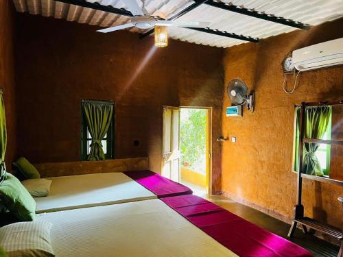 a bedroom with a large bed with a purple rug at Niwana Resort in Ratnapura