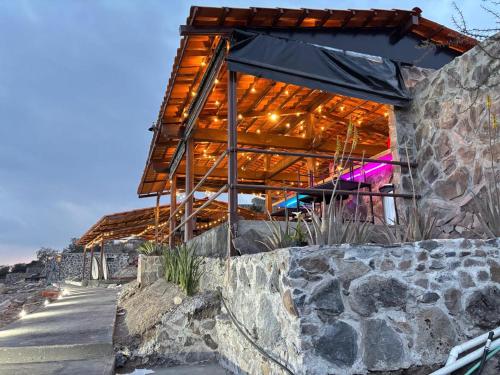a building with a stone wall next to a sidewalk at Complejo Turístico Mixcóatl in San Martín de las Pirámides