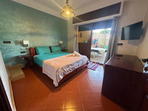 a bedroom with a bed with green sheets and a window at Villa L'initiale in Oualidia
