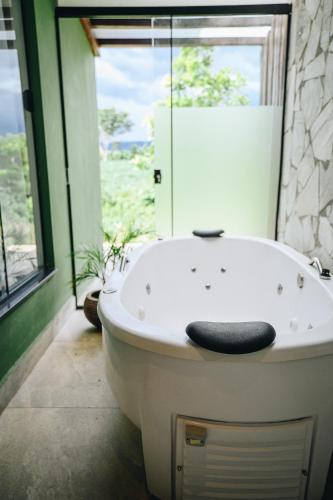 a white bath tub in a bathroom with a window at Pousada do Dione in Delfinópolis