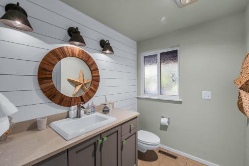 a bathroom with a sink and a mirror at Shaws Cove Beachouse in Gig Harbor
