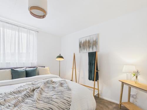 a bedroom with a bed and a painting on the wall at The Bridge View Apartment in Hawick