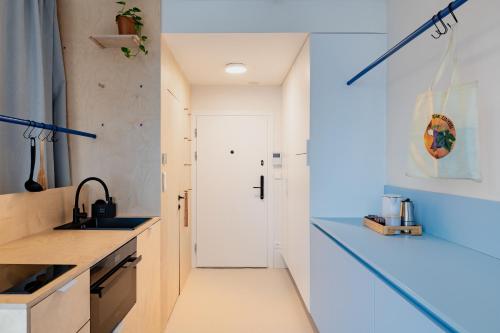 a kitchen with white counters and a sink at Super apartmán - self check in, free private parking, balcony in Banská Bystrica