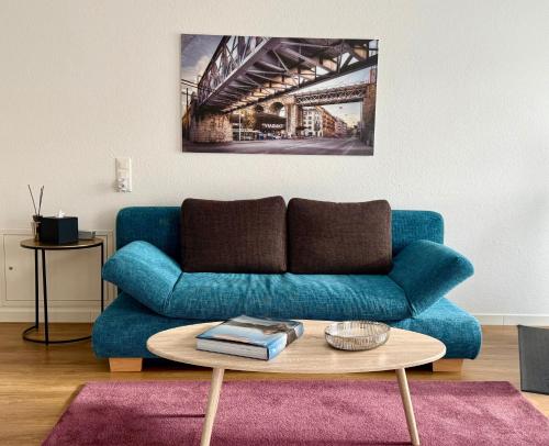 a living room with a blue couch and a table at Stilvolles Wohnen an der Goldküste, nahe Zürich - 55m2 in Erlenbach