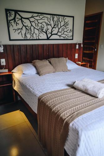 a bedroom with two beds with white sheets at Pousada do Dione in Delfinópolis
