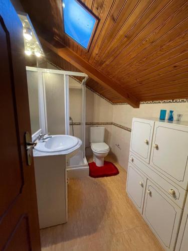 a bathroom with a sink and a toilet with a window at Vino Domus in Cabeção