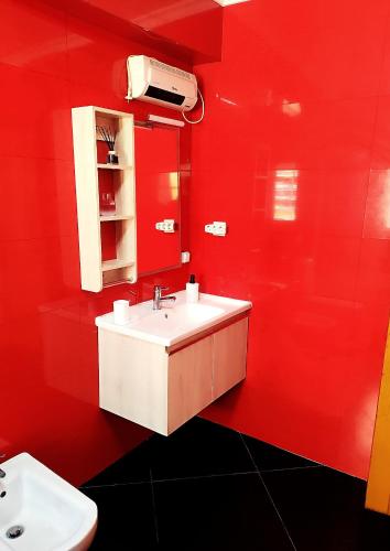 a red bathroom with a sink and a red wall at Casa da Avó Maria in Podence