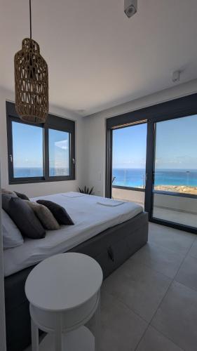 a bedroom with a bed with a view of the ocean at Villa Zina mit Infinity-Pool und Meerblick in Sitia