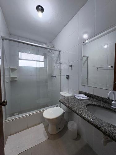 a bathroom with a toilet and a sink and a shower at Maré Leve Maresias in Maresias