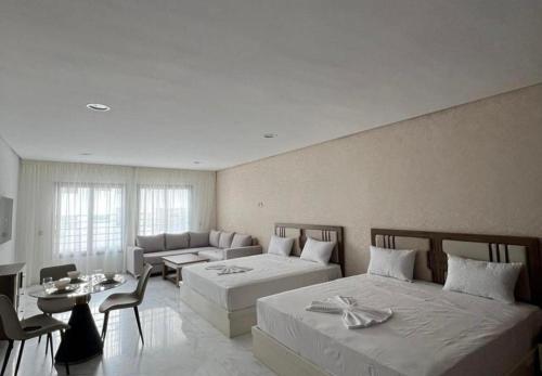 a hotel room with two beds and a couch at Central Sweet Stay in Tangier