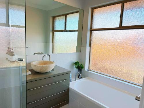 a bathroom with a tub and a sink and a window at Ocean View Sunset Resort in Perth
