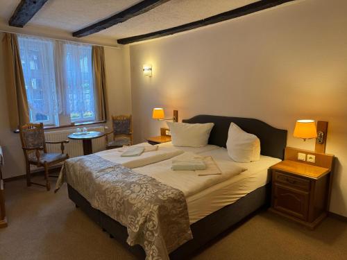 a bedroom with a large bed with two towels on it at Gasthaus Kupfer in Stolberg
