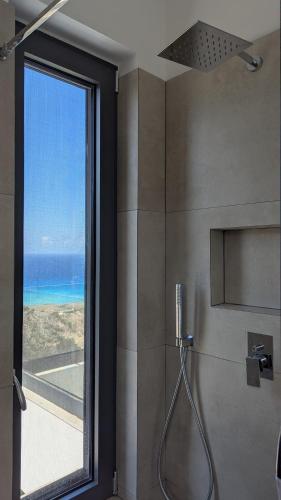 a bathroom with a shower with a view of the ocean at Villa Zina mit Infinity-Pool und Meerblick in Sitia