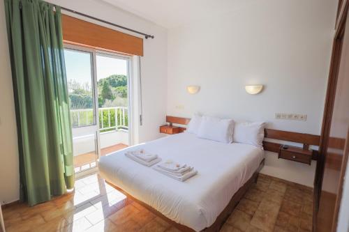 a bedroom with a bed and a large window at Residencial Campo-Mar by Umbral in Portimão