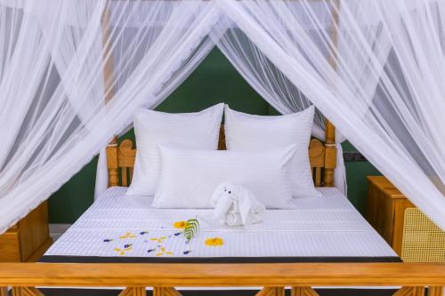 a bed with a canopy with a stuffed elephant on it at Noeline Villa in Bentota