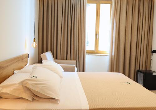 a bedroom with a bed with white sheets and pillows at Tower Suite Trento in Trento