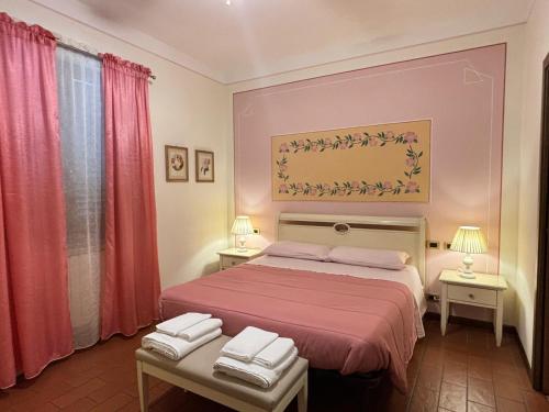 a bedroom with a bed and two tables with towels at Locanda Fuoriporta in Cantagrillo