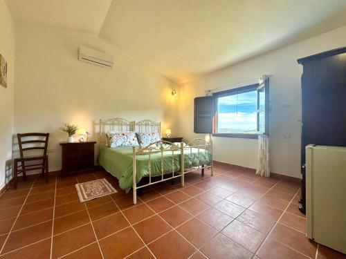 a bedroom with a bed and a chair and a window at Country Guest House in Cardedu
