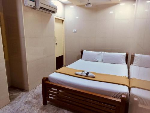 a small bedroom with a bed with a shoe on it at Hotel Mtc Guest House in Chennai