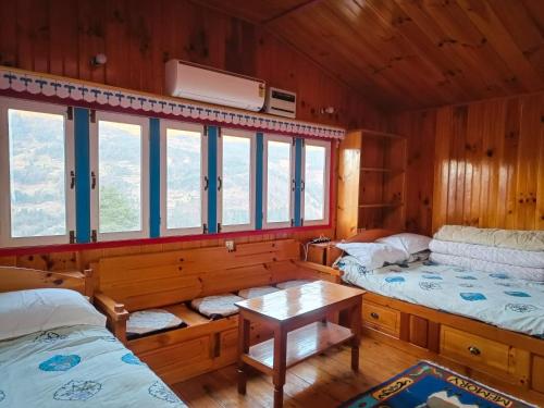 a room with two beds and a table and windows at Sagun's Place in Phāphlu