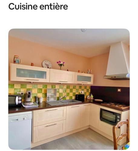 Maison provençale في Céreste: مطبخ بخزائن بيضاء وبلاط أخضر على الحائط