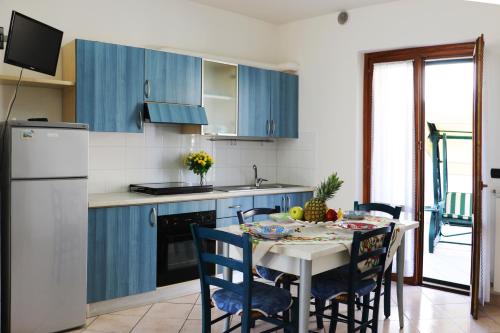a kitchen with blue cabinets and a table with chairs at Residence Acquamarina in San Benedetto del Tronto