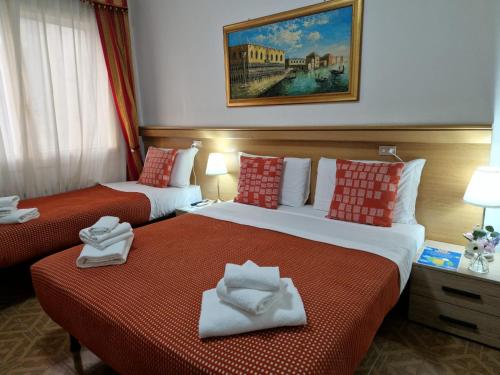 two beds in a hotel room with towels on them at Hotel Tito in Mestre