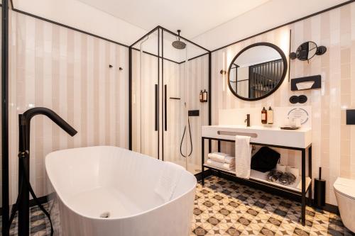 a bathroom with a tub and a sink and a mirror at Axis Porto Club Aliados in Porto
