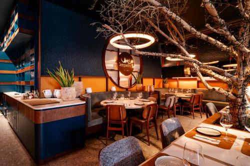 a restaurant with tables and chairs and a tree at Axis Porto Club Aliados in Porto