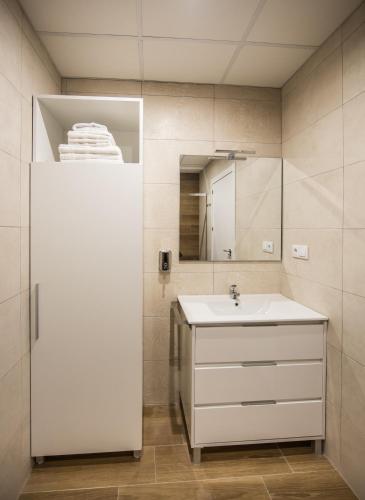 a bathroom with a white sink and a mirror at Apartamentos Ciudad del Cava in Almendralejo