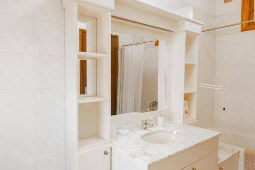 a white bathroom with a sink and a mirror at La madonnuccia in Deruta