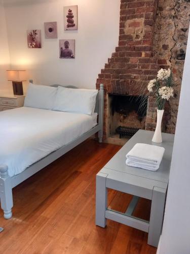 a bedroom with a bed and a table and a fireplace at Number Four in Brighton & Hove