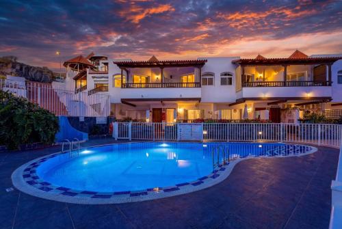 a villa with a swimming pool at dusk at Seaview Oasis Luxury Duplex La Caleta in Adeje