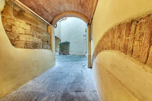 an empty hallway with a brick wall and an archway at Ele Home in Siena