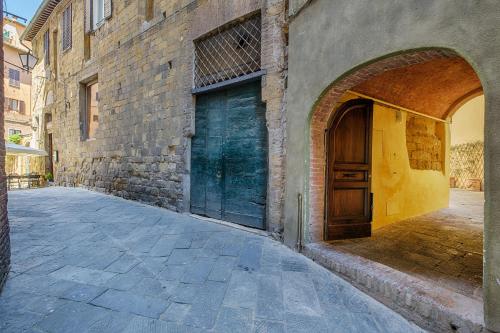 an alley with a door and a brick building at Ele Home in Siena