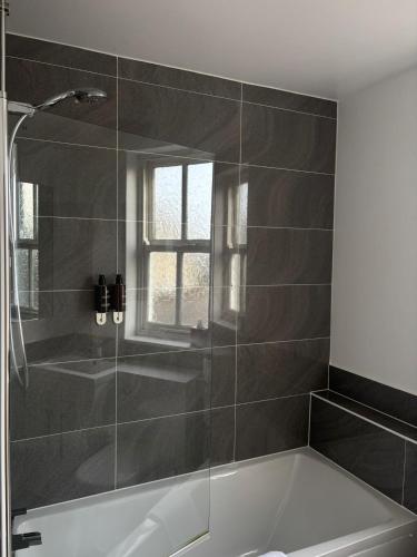 a bathroom with a bath tub and a window at Feildens Arms Hotel in Blackburn