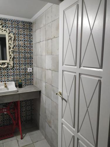 a bathroom with a white door and a sink at Apartamento Trasiego in Valdepeñas