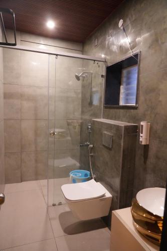 a bathroom with a shower and a toilet and a sink at CSK Comforts in Tumkūr