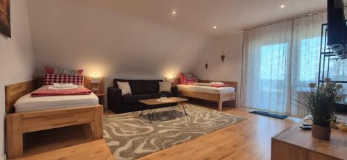 a living room with a bed and a couch at Renatas Ferienwohnung ISABEL in Sasbachwalden