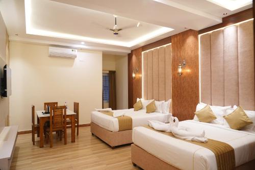 a hotel room with two beds and a table at CSK Comforts in Tumkūr