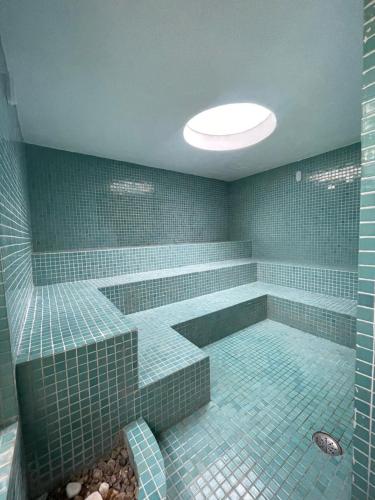 a blue tiled bathroom with a tub and a shower at Suíte aconchegante beira mar - Suíte 255 in Guarujá