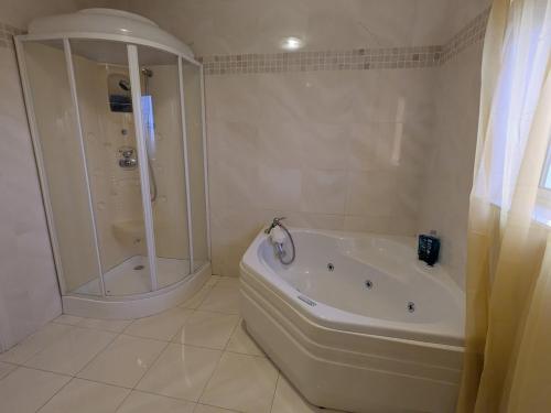a white bathroom with a tub and a shower at Cloonacauneen House in Balnacart