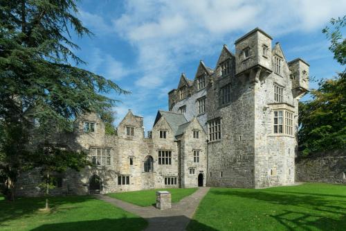 an old castle with a green lawn in front at No.3 Mill Park a luxury self-catering apartment in Donegal