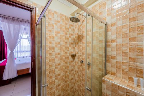 a shower with a glass door in a bathroom at Divine Homes Resort Kisumu in Kisumu
