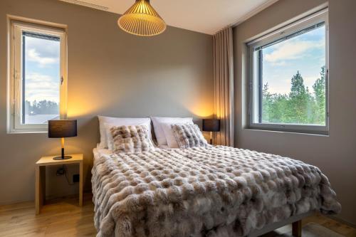 a bedroom with a large bed and two windows at Levi City Suite - Central & Stylish with Free Ski Passes in Levi