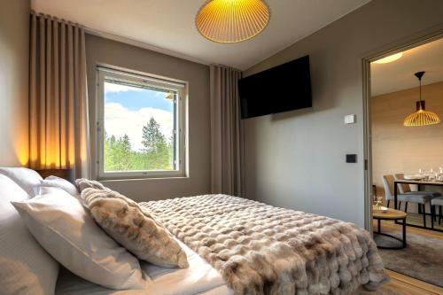 a bedroom with a large bed and a window at Levi City Suite - Central & Stylish with Free Ski Passes in Levi