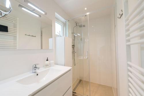 a white bathroom with a sink and a shower at Lovely Duplex Axime with beautiful hill views - Malmedy in Malmedy