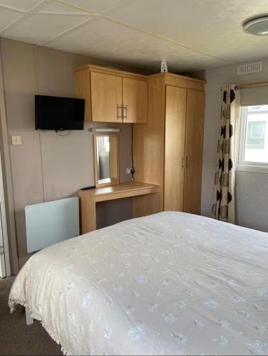 a bedroom with a bed and a tv and cabinets at Seaside Arizona in Morecambe