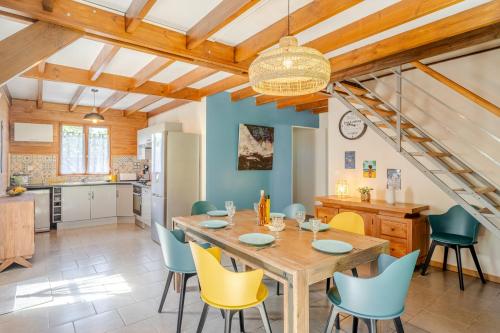 a kitchen and dining room with a wooden table and chairs at Barbadine974, Chalet cosy, 6 personnes, Plaine des Cafres in La Plaine des Cafres
